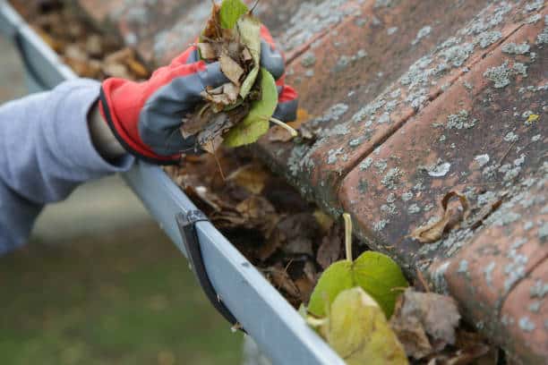 Denver Gutter Cleaning - Cleaning the gutter from autumn leaves before winter season. Roof gutter cleaning process.