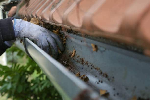 Denver Gutter Cleaning - Cleaning the gutter from autumn leaves before winter season. Roof gutter cleaning process.